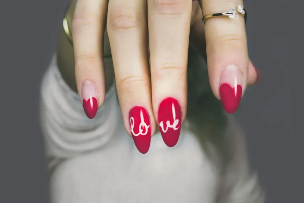Zbliżenie na dłoń kobiety z eleganckim, różowym manicure hybrydowym, podkreślającym naturalne piękno paznokci.