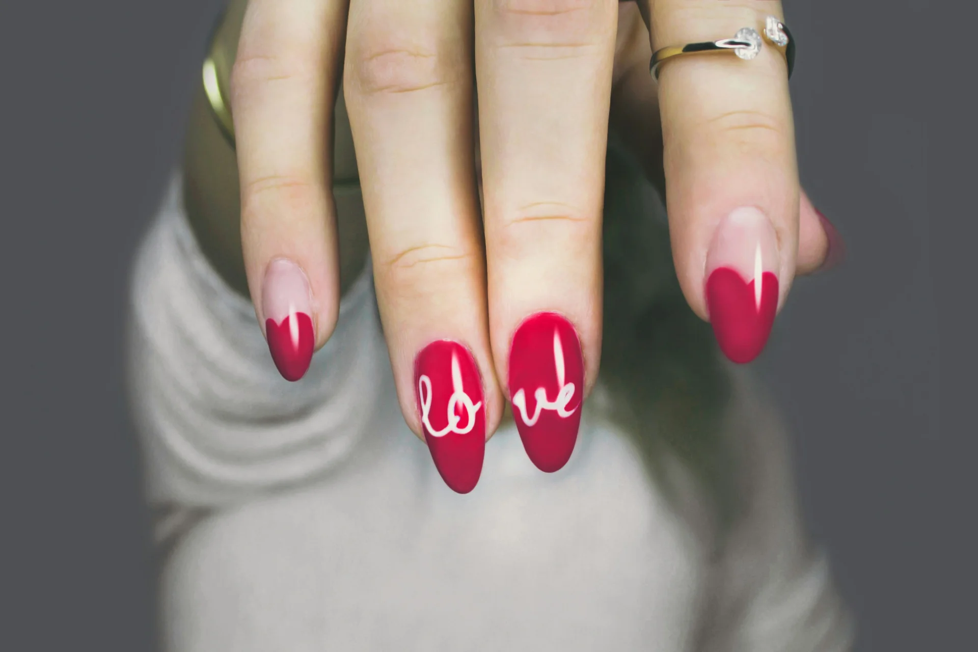 Zbliżenie na dłoń kobiety z eleganckim, różowym manicure hybrydowym, podkreślającym naturalne piękno paznokci.